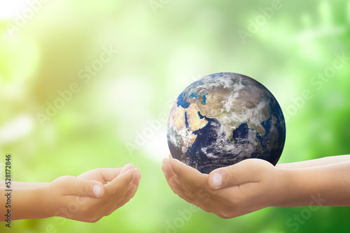 world environment day and earth day concept one hand holding a globe above the blurred forest background Elements of this image furnished by Nasa.