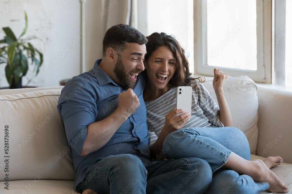 Couple read great news on phone scream with joy celebrate success, get fantastic commercial offer, bank notice about loan approval, feel happy relish moment of bet victory. Achievement, luck concept Couple read great news on phone scream with joy celebrate success, get fantastic commercial offer, bank notice about loan approval, feel happy relish moment of bet victory. Achievement, luck concept