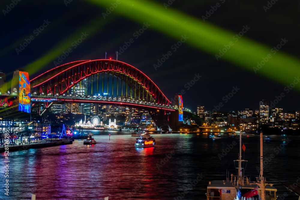 冬のシドニーのイベント・ビビッドシドニーで見た、赤くライトアップされるハーバーブリッジと周辺の夜景