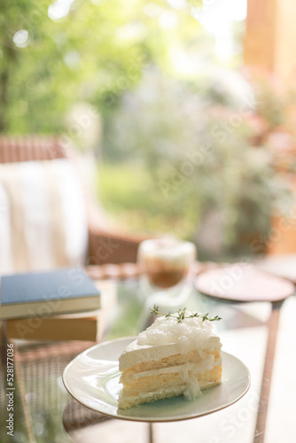 Coconut Cake and Coffee in a cafe on the blur background. traditional dessert Sliced of delicious coconut layer cake