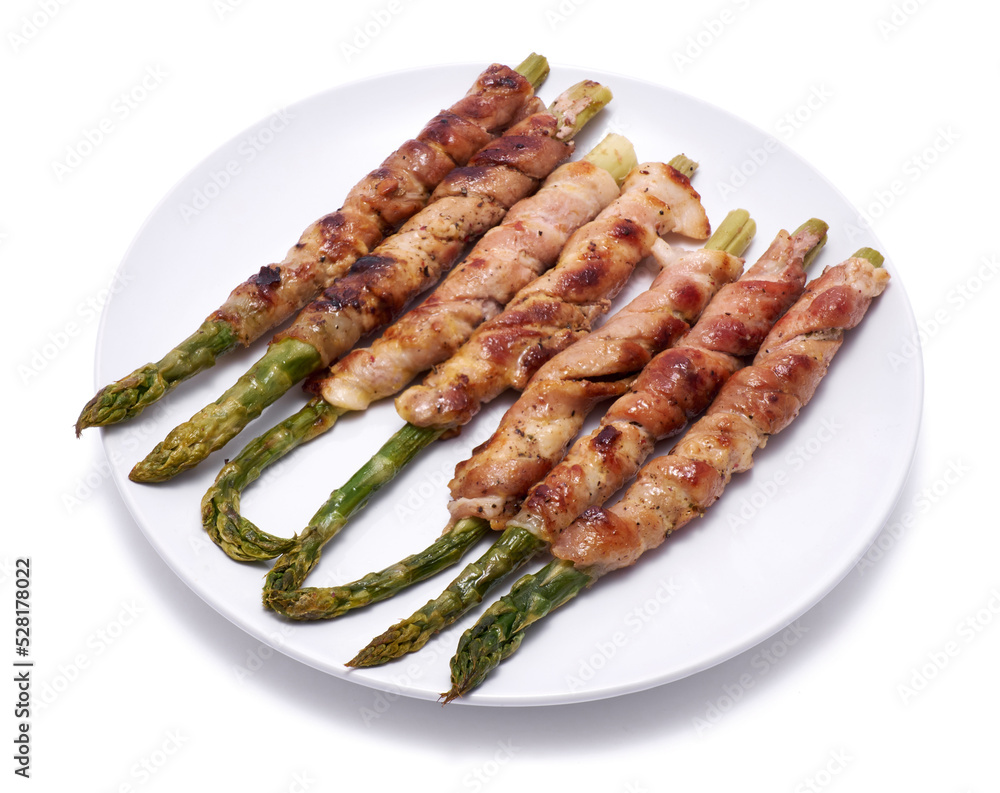 Healthy food - Asparagus wrapped with bacon and spices on a plate isolated on white background Healthy food - Asparagus wrapped with bacon and spices on a plate isolated on white background