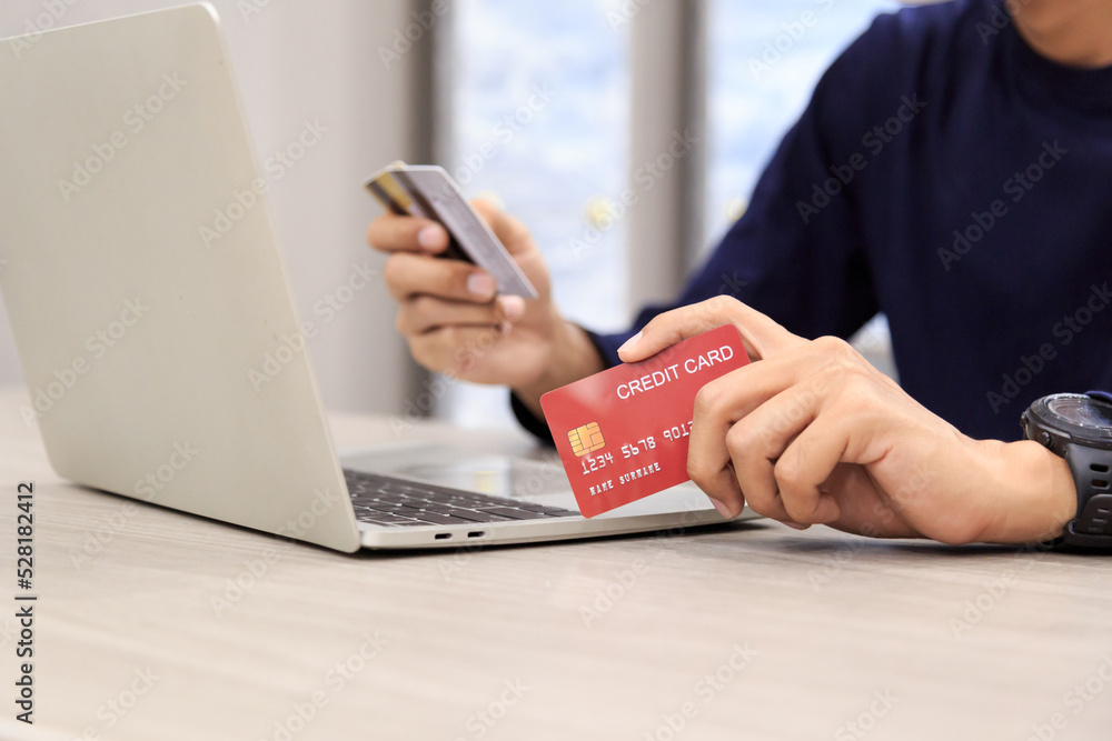 Fototapeta premium Businessman holding credit card for online shopping bill on smartphone, positive man shopping online remote payment , smart payment concept individual bank