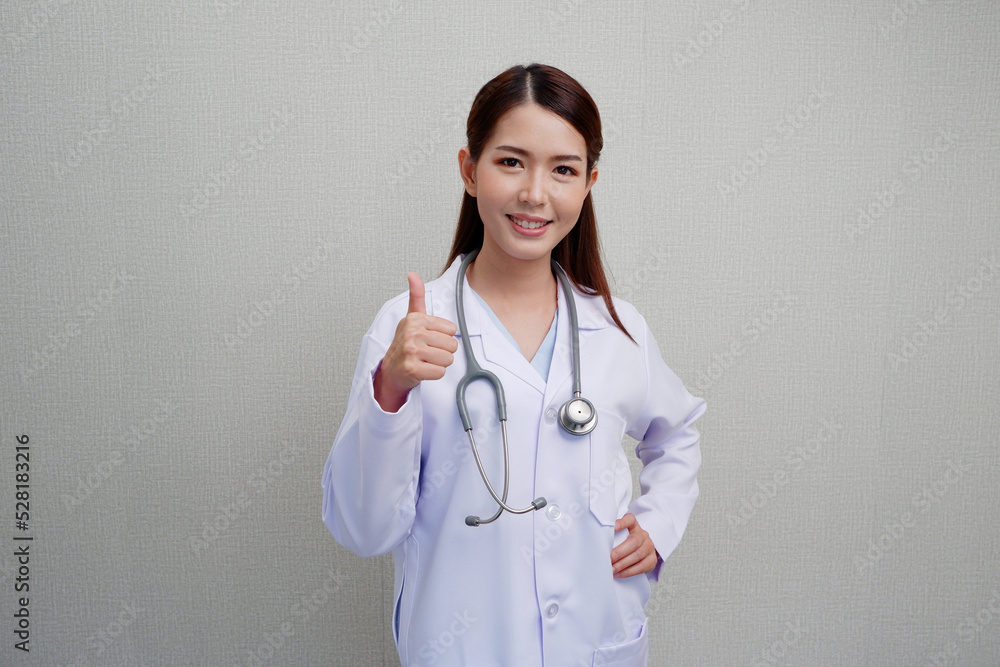 Asian female doctor standing with finger pointing at presentation with a bright smile and put the headphones on her shoulder wearing a white coat. Asian female doctor standing with finger pointing at presentation with a bright smile and put the headphones on her shoulder wearing a white coat.