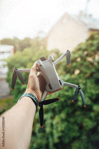 Man hand holding a small light drone, drone pilot with a drone photo