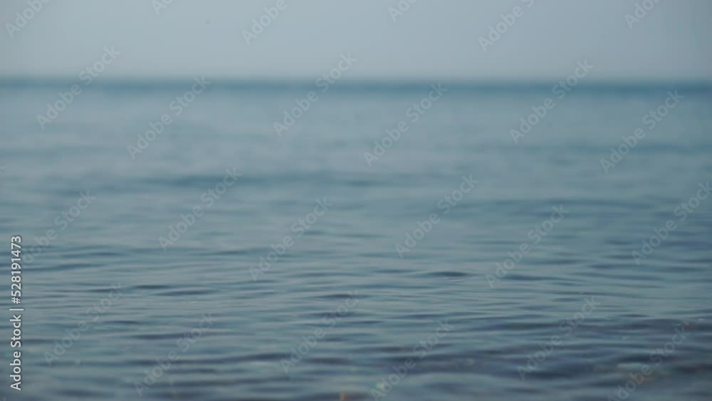 Abstract calm sea summer ocean sunset nature background. Small waves on water surface in motion blur with golden bokeh lights from sun. Holiday, vacation and recreational concept. Slow motion Abstract calm sea summer ocean sunset nature background. Small waves on water surface in motion blur with golden bokeh lights from sun. Holiday, vacation and recreational concept. Slow motion