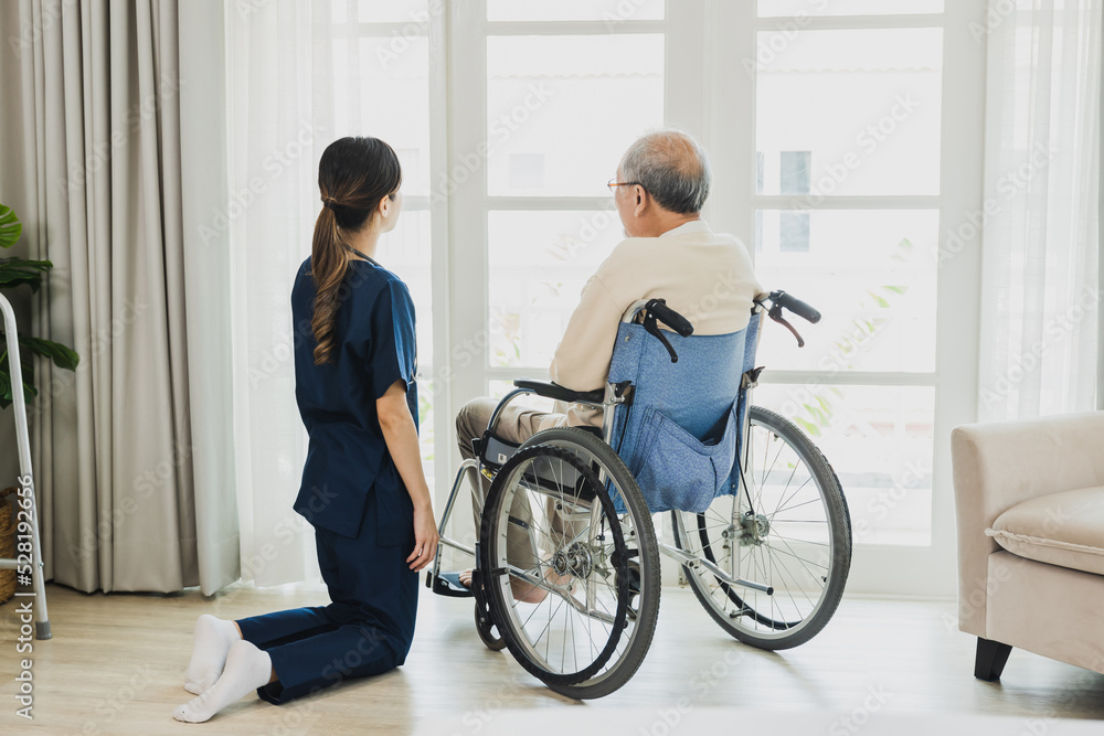 Senior Asian man in wheelchair receives medical help for injury, take care and take to looking looking out of window. Senior Asian man in wheelchair receives medical help for injury, take care and take to looking looking out of window.