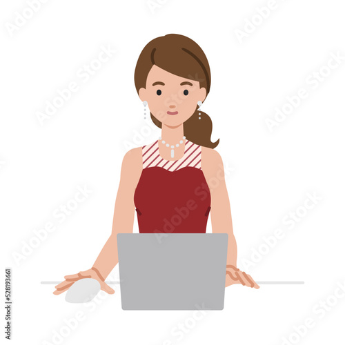 デスクで座ってPCを使っているドレスの女性