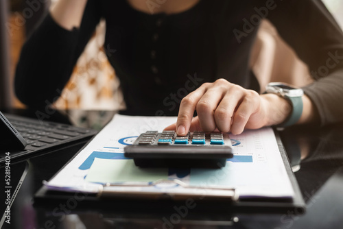 Women are using calculators to calculate office income.