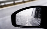 Car side mirror with water drops. Autumn weather. Cooling down and road conditions.
