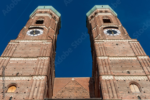 Die zwei Türme der Frauenkirche in der Altstadt von München in extremer Unteransicht bei sonnigem Wetter und blauem, wolkenlosen Himmel photo