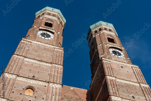 Die zwei Türme der Frauenkirche in der Altstadt von München in extremer Unteransicht bei sonnigem Wetter und blauem, wolkenlosen Himmel photo