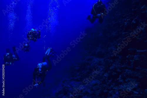 divers underwater at depth in the blue sea background © kichigin19