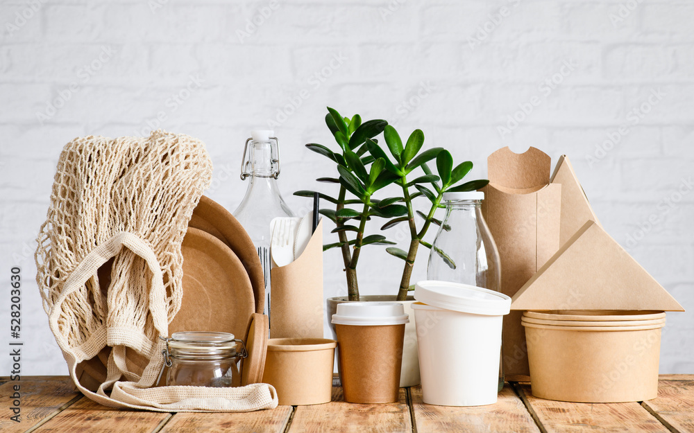 Fotka „Ecofriendly paper and glassware around a green houseplant. The