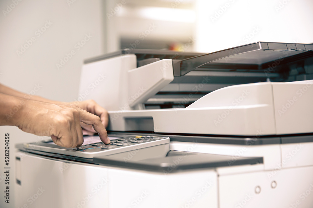 Photocopier printer, Close up hand office man press copy button on panel to using the copier or photocopy machine for scanning document or printing paper or Xerox a sheet. - obrazy, fototapety, plakaty 