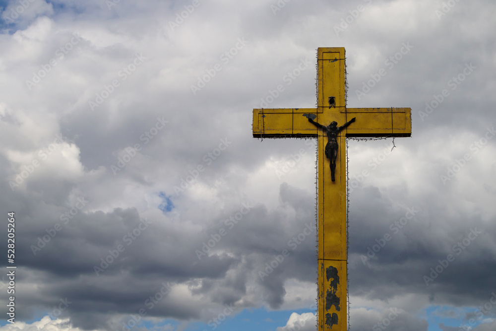 A large cross on a background of clouds with free space for text