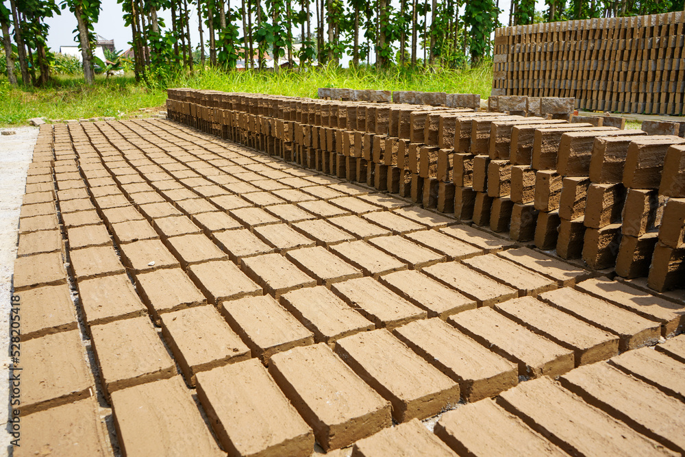 Red bricks from clay. After the clay is molded into bricks, after that it is laid out and dried in the yard in the sun before being burned to make it hard and dry. Pile of making batu bata merah. Red bricks from clay. After the clay is molded into bricks, after that it is laid out and dried in the yard in the sun before being burned to make it hard and dry. Pile of making batu bata merah.