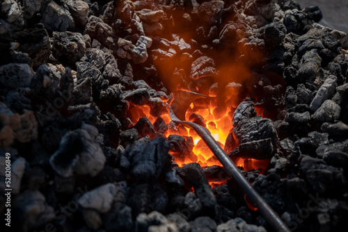 Fornalha medieval com carvão ardente e um ferro em aquecimento para depois de aquecido poder ser trabalado photo
