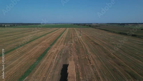 pressed straw on a truck with a trailer in the field, aerial view. Agriculture photo