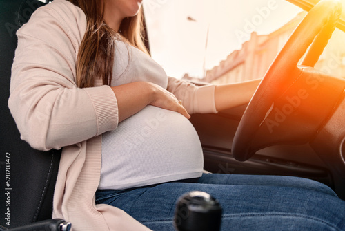 Pregnancy woman driving car. Young smiling pregnant woman driving car. Safety pregnancy young mother drive concept. © Maksym