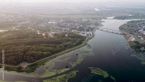 ultra hd video footage 4k Aerial drone view of Balloons fly over the Volga River in Russia. Expanse of the riverside of the Volga near the city of Kostroma at summer  sunset