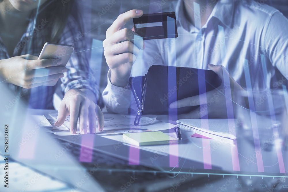 Fototapeta premium Double exposure of man and woman on-line shopping holding a credit card and forex graph hologram drawing. Stock market E-commerce pay on-line concept.