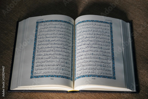 Indonesia - July, 2022 : The Quran, also romanized Qur'an or Koran, is central religious text of Islam, believed by Muslims to revelation from God (Allah). Classical Arabic. Sack, Blue. white. Open.