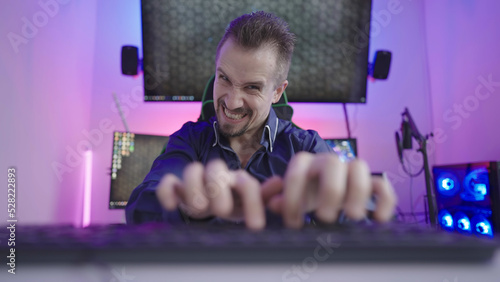 Mad male person typing with rage on computer from keyboard point of view photo