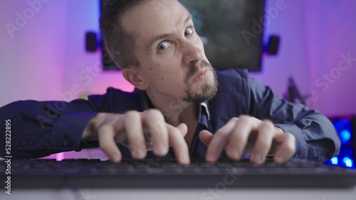 Online troll rage trashing on keyboard making faces in cyberspace photo