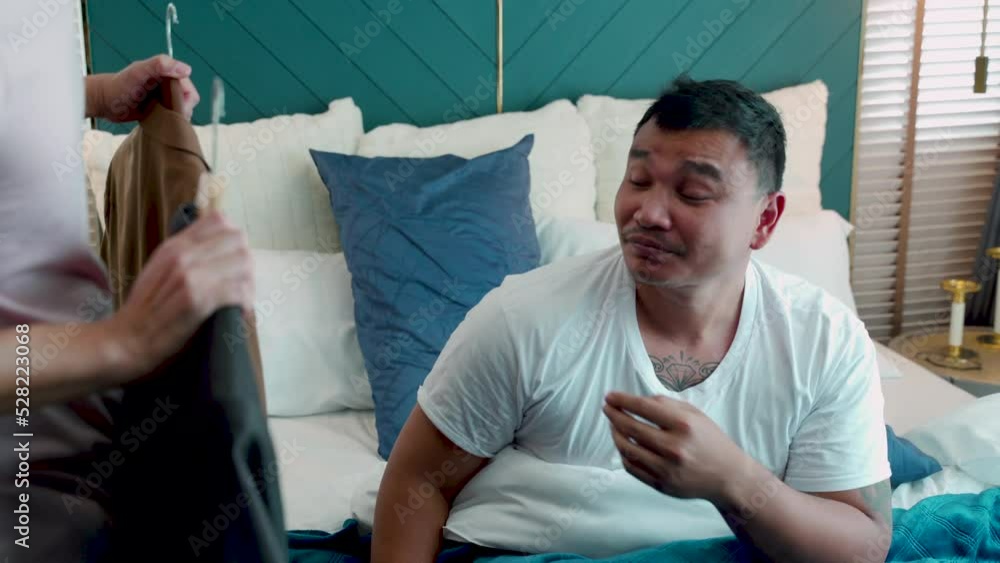 4K, Asian male love couple getting out of bed in the house. A lover is bringing a work shirt to another man to wear to work in the morning of the day. The love, and friendship of LGBTQ couples. 4K, Asian male love couple getting out of bed in the house. A lover is bringing a work shirt to another man to wear to work in the morning of the day. The love, and friendship of LGBTQ couples.