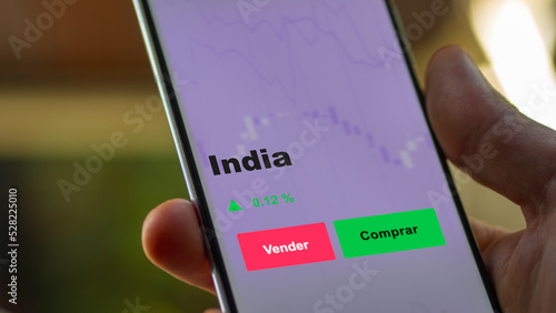 Un inversor está analizando el india etf fondo en pantalla. Un teléfono muestra los precios del ETF INDIA para invertir.