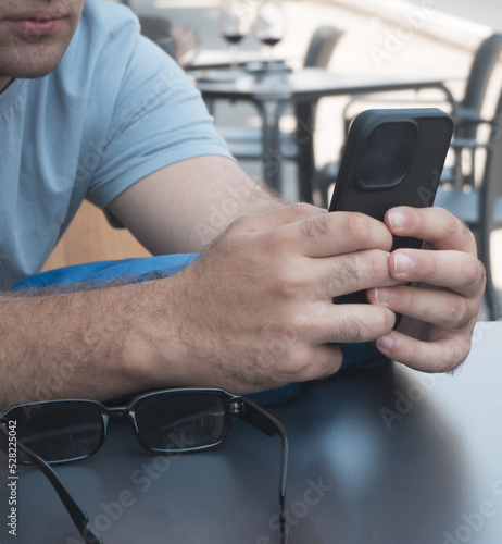 Close-up of a young man interacting with his smartphone. Technology concept.