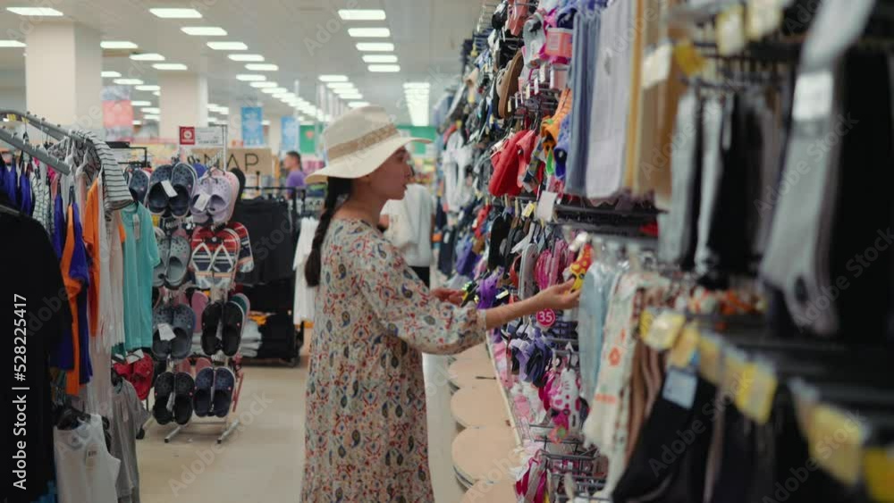 Woman looking for a flip-flops in supermarket Woman looking for a flip-flops in supermarket