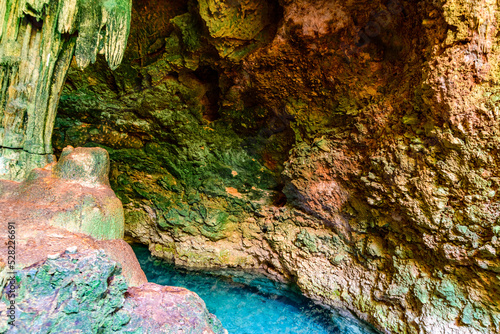 Stalactites and stalagmites in a Kuza cave at Zanzibar, Tanzania. Natural pool with crystal clear water