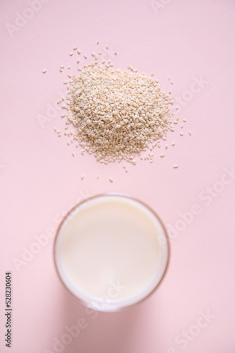 Top view drinking glass of healthy nutritious white non dairy drink. Alternative plant based milk from sesame seeds photo