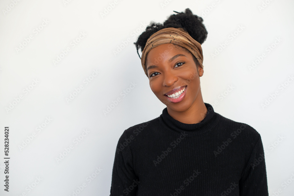 Portrait of good-looking African American woman. Female model in black long sleeve shirt against white background, looking at camera, smiling. Portrait, beauty, studio photoshoot concept Portrait of good-looking African American woman. Female model in black long sleeve shirt against white background, looking at camera, smiling. Portrait, beauty, studio photoshoot concept