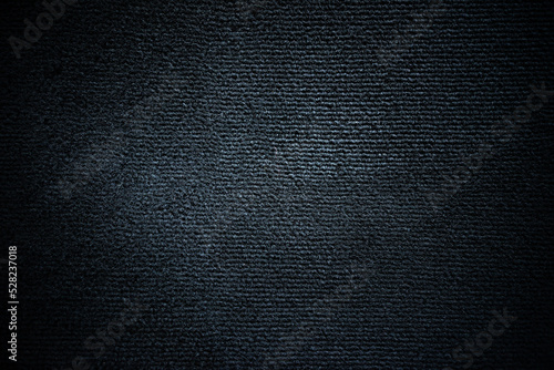 Photo of the texture of a black pile carpet in a car.Black soft background for text.