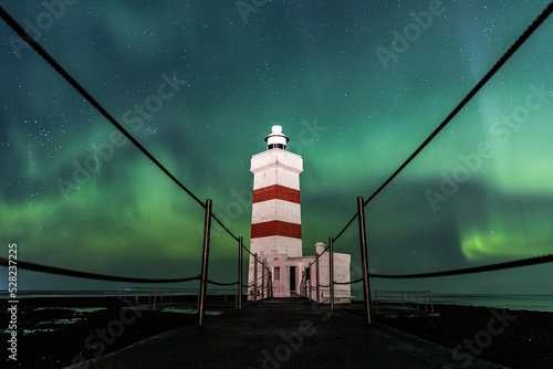 Iceland Northern Lights in winter near a Garður Old Lighthouse  photo