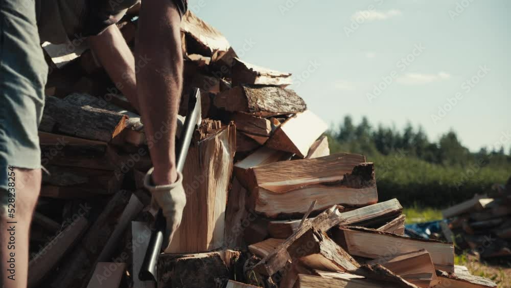 Slow motion of strong male worker chopping wood in backyard outdoors, swinging and hitting wooden log with axe, splitting timber into half. Lumberjack man working outside, stacking firewood in pile. Slow motion of strong male worker chopping wood in backyard outdoors, swinging and hitting wooden log with axe, splitting timber into half. Lumberjack man working outside, stacking firewood in pile.