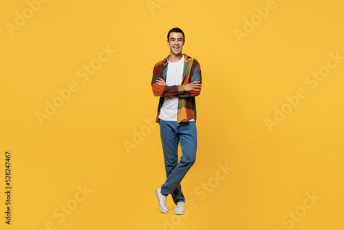 Full body young smiling happy middle eastern man 20s wear casual shirt white t-shirt look camera hold hands crossed folded isolated on plain yellow background studio portrait People lifestyle concept.