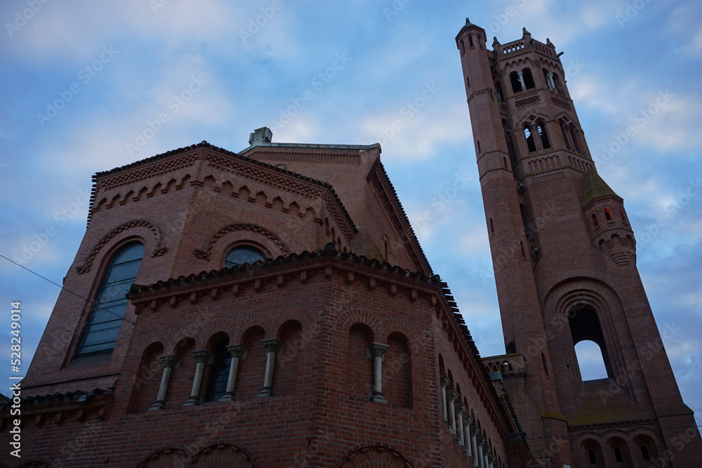 view of a red brick church and tall bell tower in france