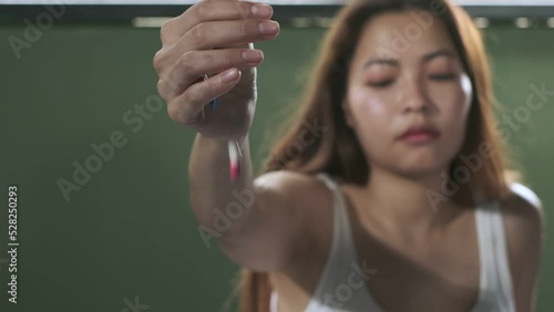 Hand of cute woman wearing white tank top overdosed sprinkle medicine pills to the floor,slow motion shot.