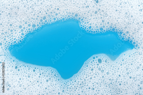 Soap foam. Background of dusty foam with bubbles of blue color for an inscription. Soap sud with copy-space