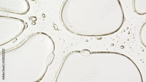Transparent cosmetic gel fluid with molecule bubbles oil distribution on a white background. Macro Shot of Natural Organic Cosmetics, Medicine. Production Close-up. Slow Motion. High quality 4k