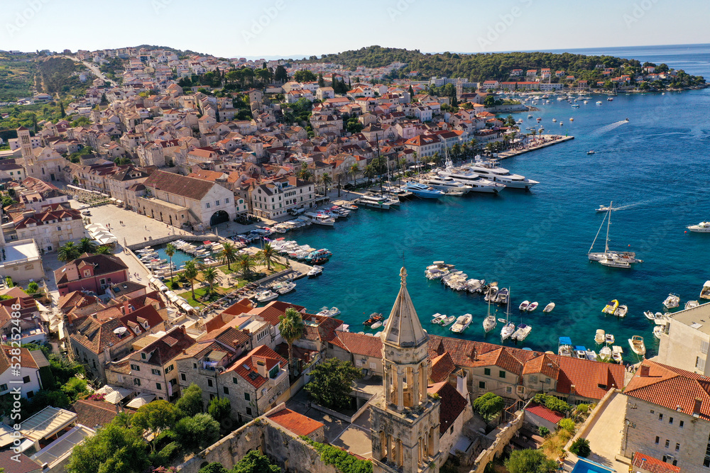 Croatian Island Hvar Harbor in Summertime with multiple moored Yachts and boats.