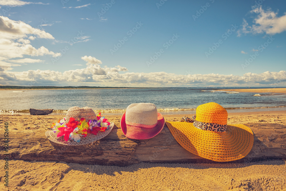 Trzy plażowe kolorowe kapelusze, słoneczny plażowy dzień, piasek.  - obrazy, fototapety, plakaty 