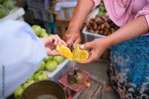 hand cutting citrus fruit with knife