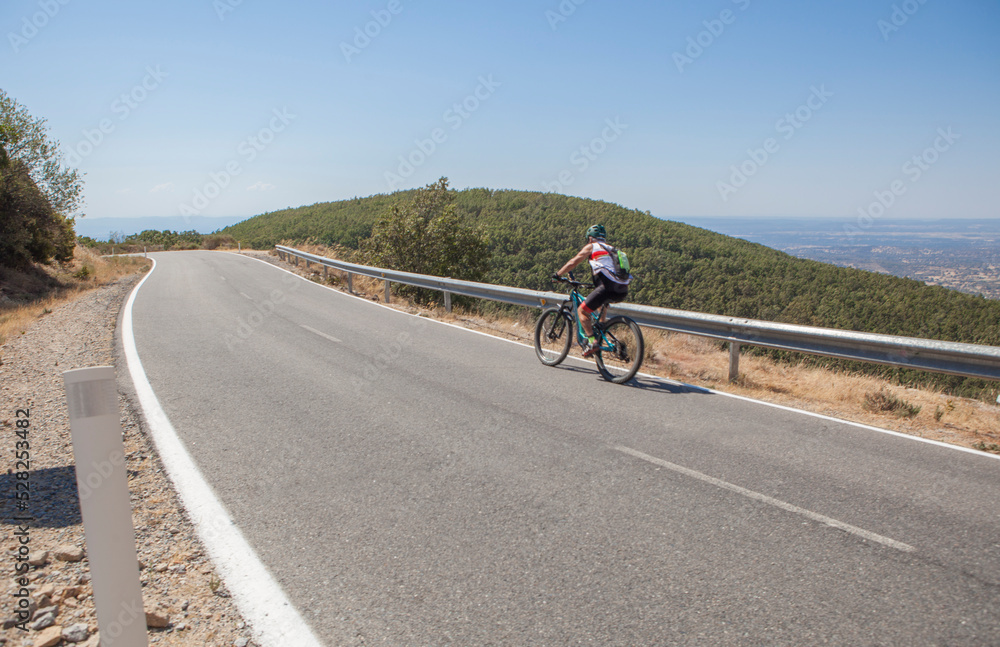 Senior cyclist speeding down winding road Senior cyclist speeding down winding road