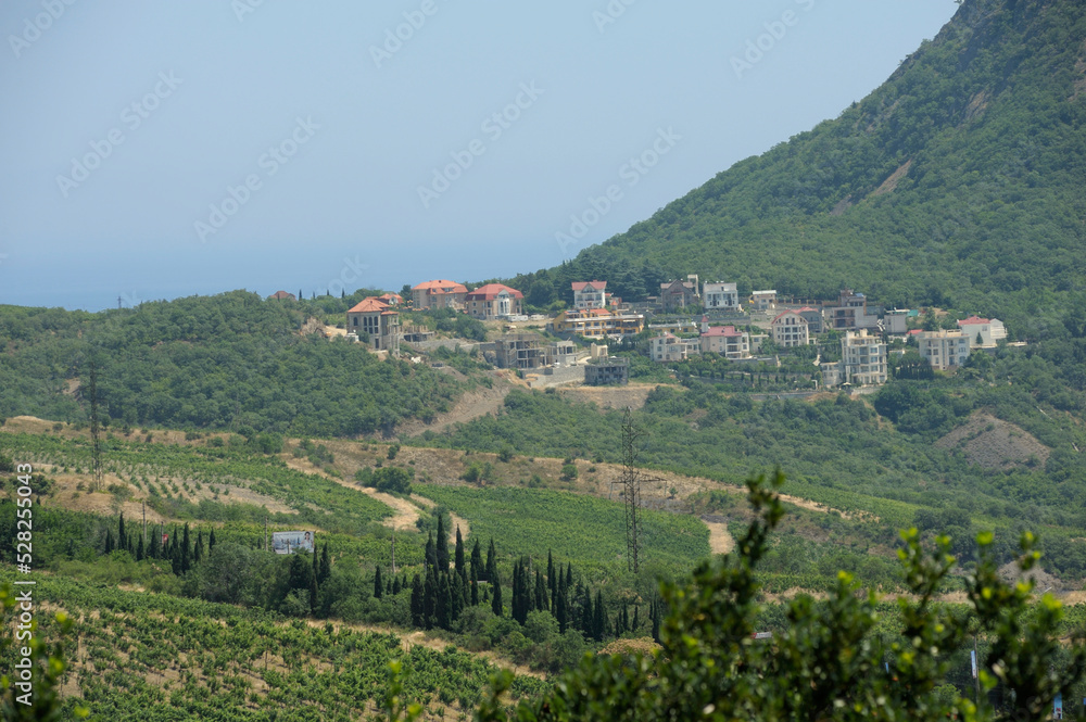 Southern coast of the Black Sea landscape. Sea mountains trees buildings. Place near resort town Gurzuf, Crimea