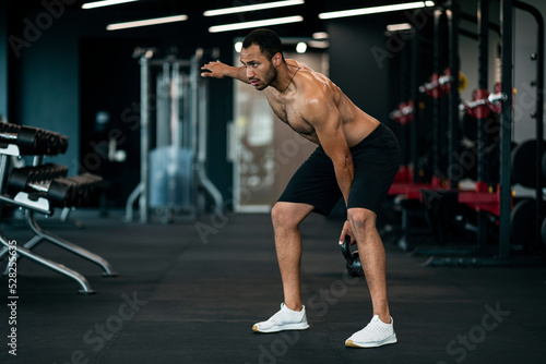 Handsome Muscular Black Sportsman Exercising With Kettlebell At Modern Gym Interior
