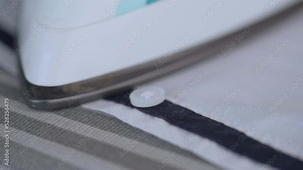 woman ironing shirt close up details iron moves around button woman ironing shirt close up details iron moves around button